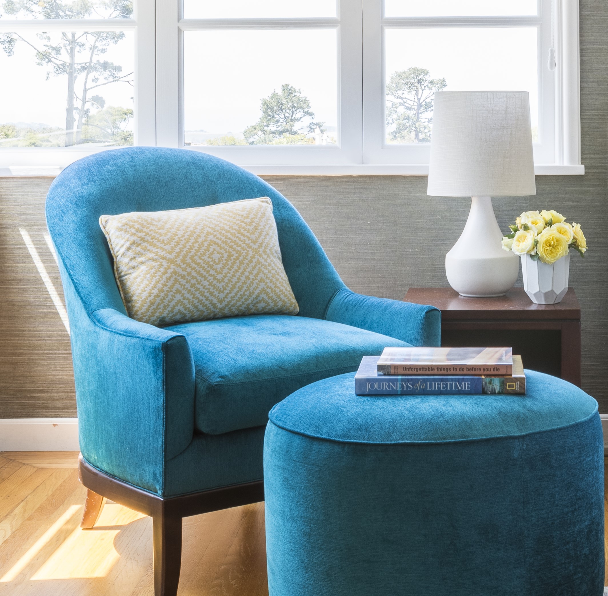 Blue lounge chair with yellow patterned accent pillow and matching ottoman