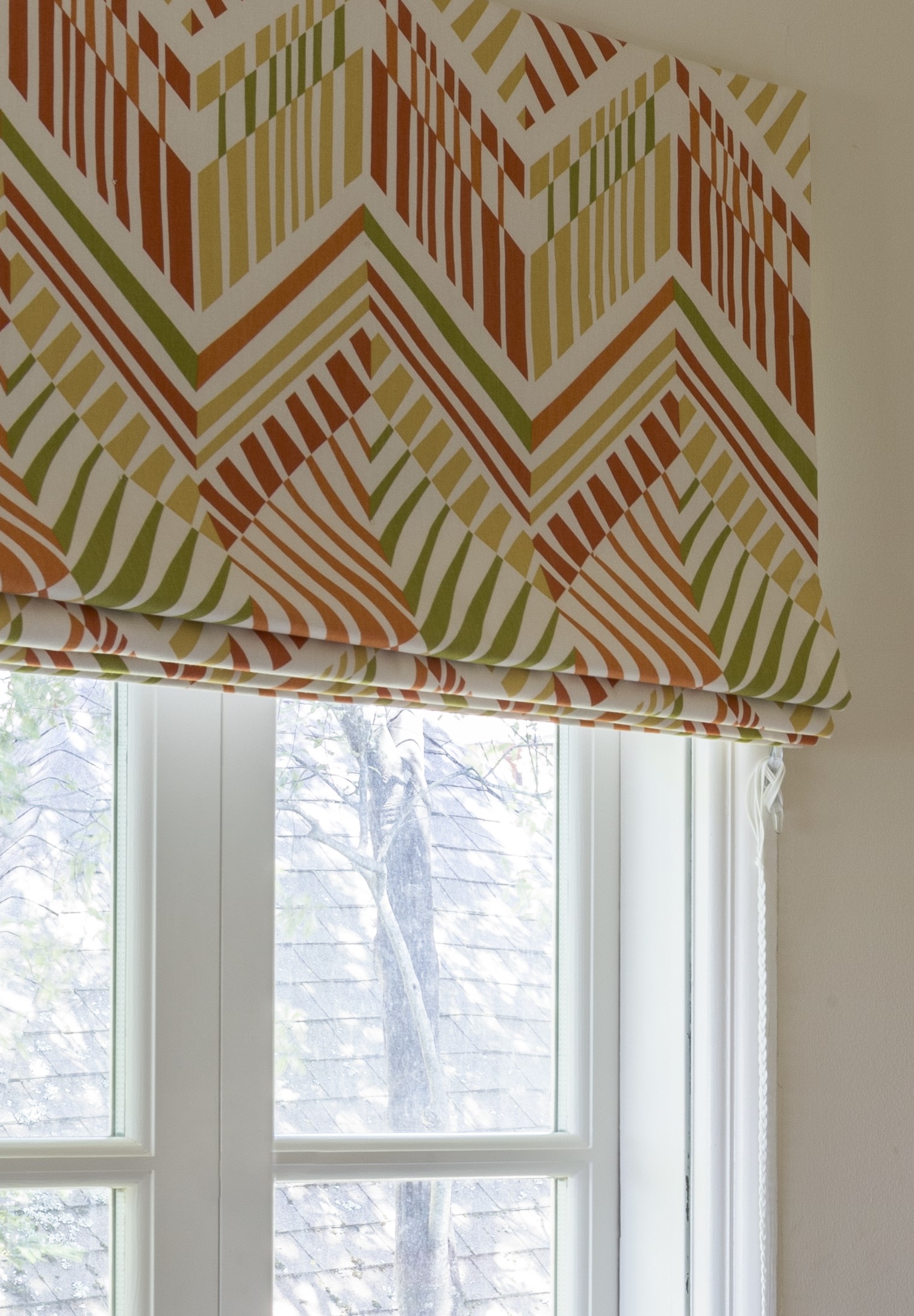 Roman shade with vibrant pink and green color scheme and lined pattern